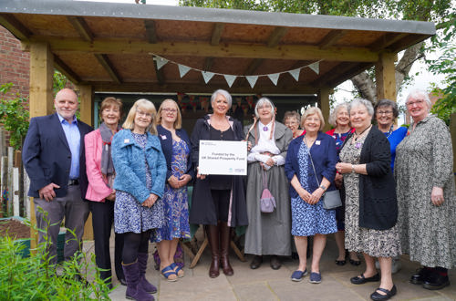 RBC Deputy Leader Cllr Abby Brennan has joined Framework Knitters Museum volunteers by the outdoor summerhouse