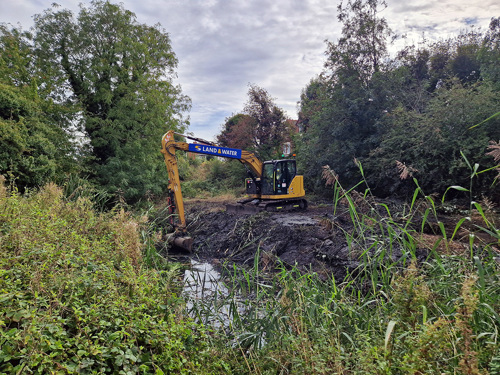 A digger clearing a ditch at a nature reserve