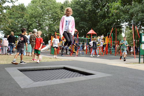 Young girl playing on a new accessible trampoline at a play park in Gamston