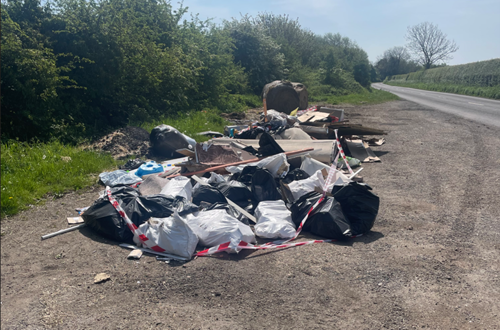 A large pile of waste left in a rural layby