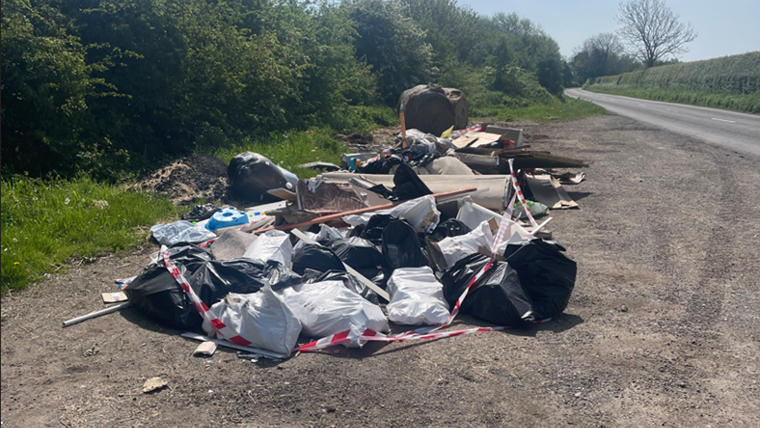 A large pile of waste left in a rural layby